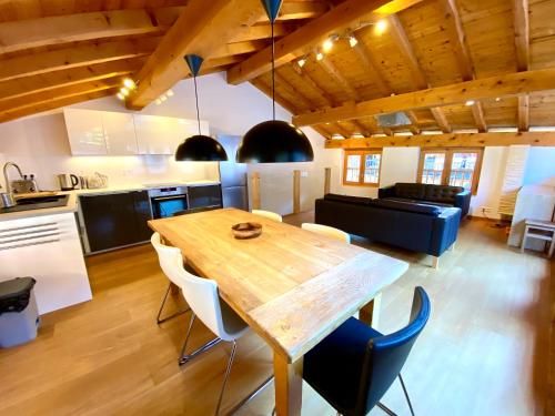 een keuken en een woonkamer met een houten tafel en stoelen bij Chalet Greuffa in Courchevel