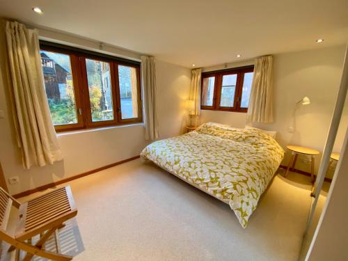 a bedroom with a bed and two windows at Chalet Greuffa in Courchevel
