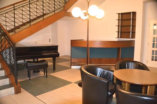 a room with a piano and a table and chairs at Masarykova Kolej in Prague