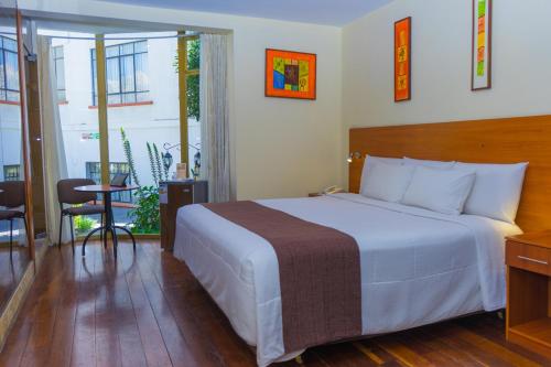 Habitación de hotel con cama y balcón en Hotel Calacoto, en La Paz