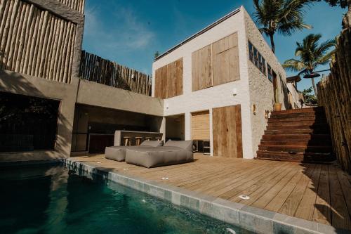 una casa con un letto su una terrazza in legno accanto alla piscina di Pousada Zinga Caraíva a Caraíva