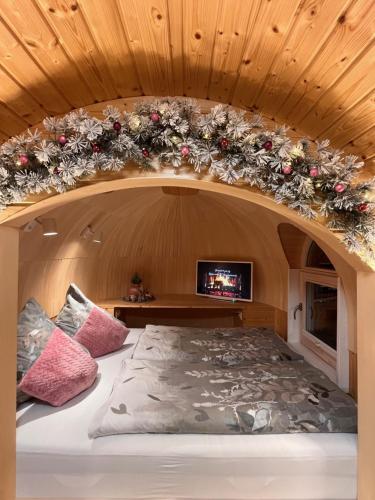 een bed in een kamer met een boog in het plafond bij Igluhut Tiny House Bayerischer Wald in Zachenberg