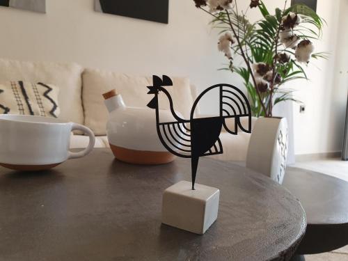 a black bird statue sitting on a table next to a cup at Costa Bianco Luxury Home in Agios Nikolaos