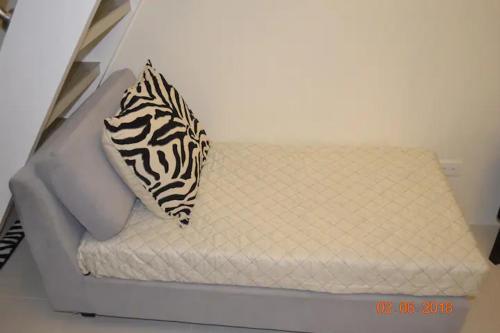 a white mattress with a zebra pillow on it at SMDC Wind Residences 102 Loft Bedroom Facing Amenities with WIFI and Parking in Tagaytay