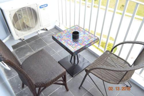 a patio with a table and chairs and a fan at SMDC Wind Residences 102 Loft Bedroom Facing Amenities with WIFI and Parking in Tagaytay