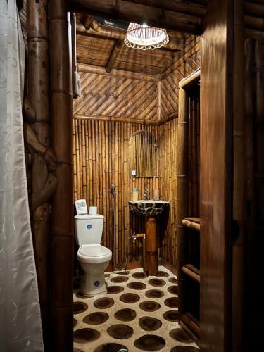 uma casa de banho com WC num edifício de madeira em Sikeo Eco Glamping em Icononzo