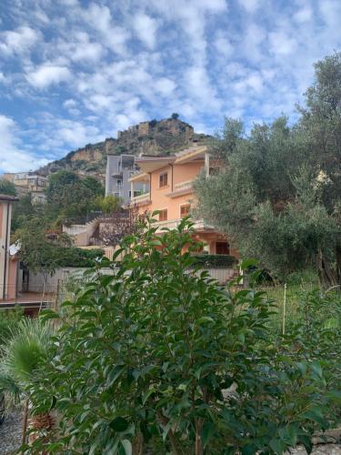 ein Gebäude mit einem Hügel im Hintergrund mit einem Baum in der Unterkunft Nel cuore di Amantea in Amantea