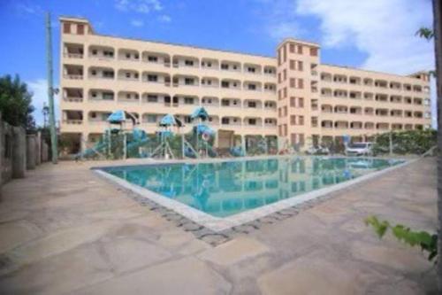 een groot gebouw met een zwembad voor een gebouw bij Classy 3 bedroom apartment in Mombasa. in Mombasa