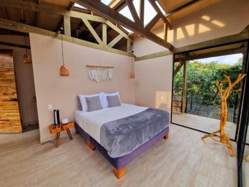 1 dormitorio con cama y ventana grande en Glamping Entrearboles - Bellavista en La Mesa