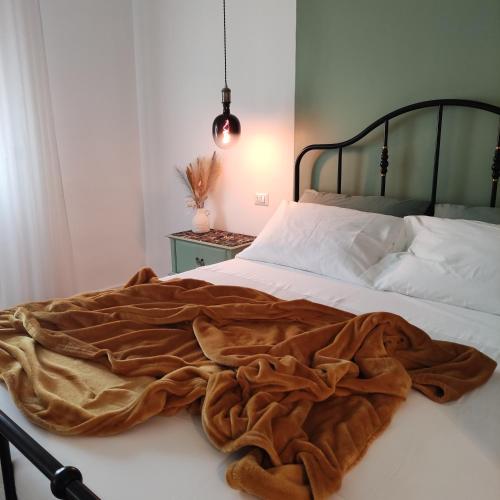 Una cama con una manta marrón encima. en Casa Tulù B&B, en Bolonia