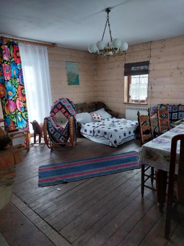 ein Wohnzimmer mit einem Bett und Stühlen in der Unterkunft Agroturystyka LipoweWzgórze domek Danusia in Tereszpol