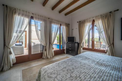 een slaapkamer met een bed en grote ramen bij Stunning detached Villa in El Valle Golf Resort - ZO24EV in Murcia