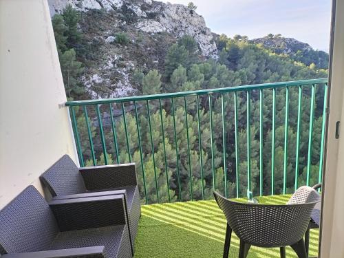 a balcony with a table and chairs and a mountain at VUE MER et montagne dans parc du roy d'espagne, Up to 7 people in Marseille