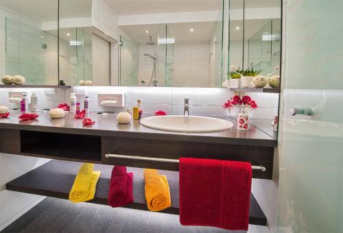 a bathroom with a sink and a counter with towels at Seehotel Princes in Sankt Kanzian
