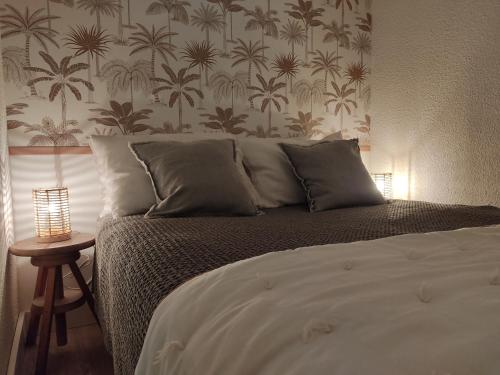 sypialnia z łóżkiem i ścianą z palmami w obiekcie Appartement cosy Saint Lary village w mieście Saint-Lary-Soulan