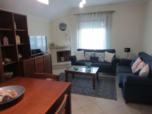 a living room with a couch and a table at Apartamento Panorâmico das Dunas da Bela Vista in Gafanha da Encarnação