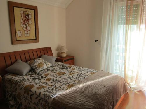 een slaapkamer met een bed en een raam bij Apartamento Panorâmico das Dunas da Bela Vista in Gafanha da Encarnação