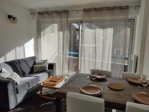 un salon avec une table et un canapé dans l'établissement Appartement cosy Saint Lary village, à Saint-Lary-Soulan