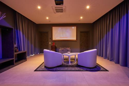 a meeting room with purple curtains and a screen at Castelmartini Wellness & Business Hotel in Larciano