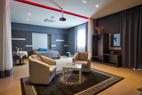 a living room with two chairs and a bed at Castelmartini Wellness & Business Hotel in Larciano