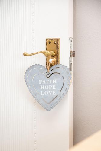 a heart shaped door latch with the words faith hope love at Settle inn Self Catering Units in Colchester