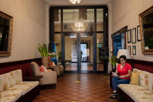 a woman sitting on a couch in a lobby at Hotel Reforma Tuxpan in Tuxpan de Rodríguez Cano