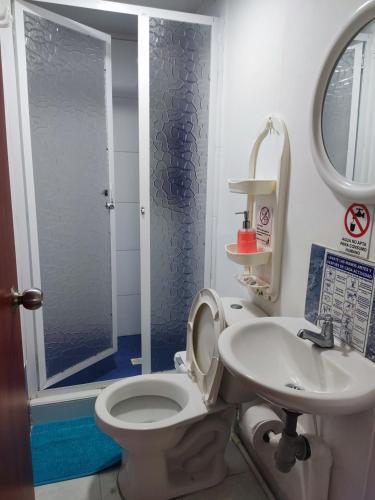 a bathroom with a toilet and a sink and a shower at Posada San Nicolas in San Andrés