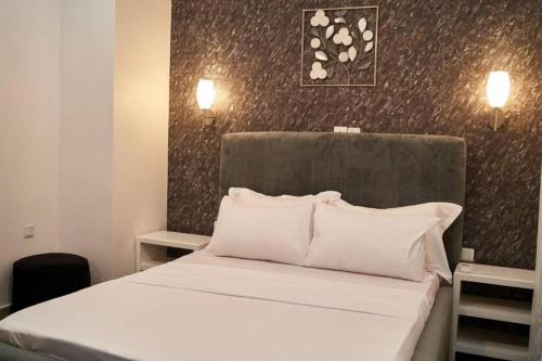 um quarto com uma cama com duas almofadas brancas em Appartement cosy or bonapriso em Douala