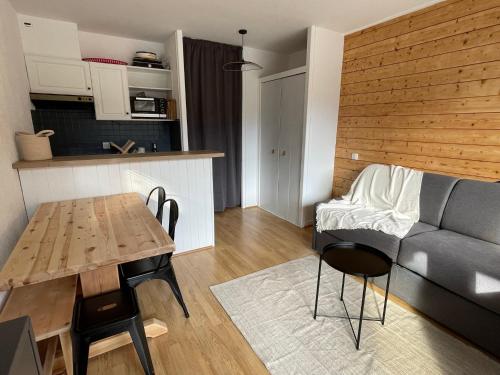 un salon avec une table et un canapé dans l'établissement Bel appartement rénové, central et skis aux pieds, à Morzine