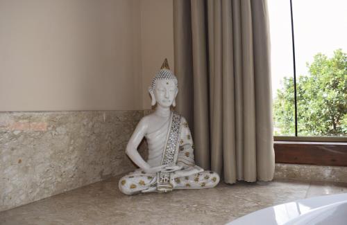 a statue sitting on the floor in a room at Pousada Lua Clara in Alto Paraíso de Goiás