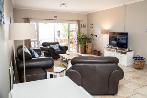 a living room with leather furniture and a television at Settle inn Self Catering Units in Colchester