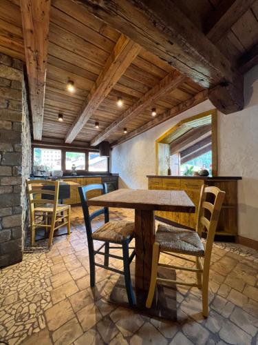 a dining room with a wooden table and chairs at La Maisonette 1878 in Dosoledo