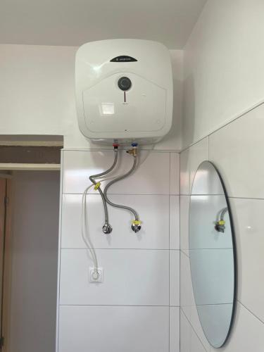 a camera on the wall of a bathroom with a mirror at Apartamento T2-Dunas Centro in Tarrafal