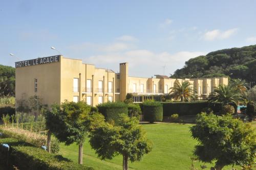 a large building with trees in front of it at Residence Le Acacie in Capoliveri