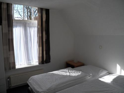 a bedroom with two beds and a window at House@Domburg in Domburg