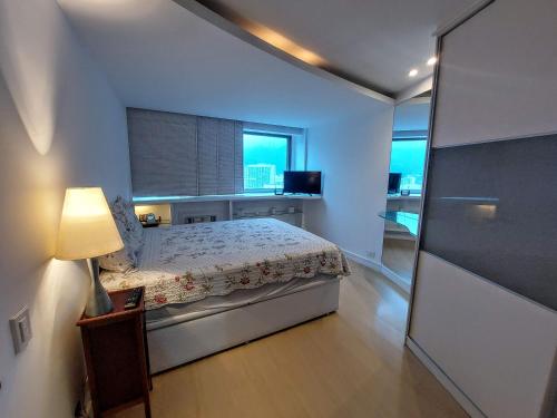 Habitación pequeña con cama y ventana en Maravilhoso flat no Leblon, en Río de Janeiro
