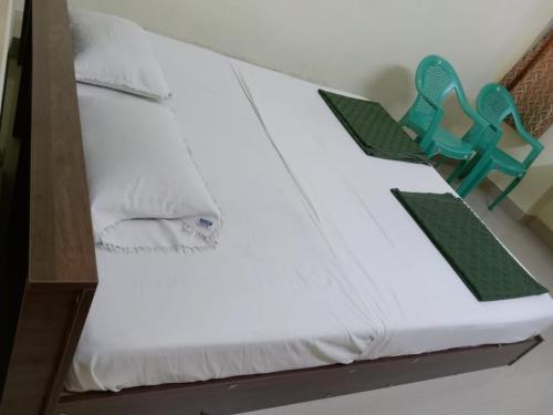 a bed with two chairs sitting on top of it at BSSK Comforts Inn in Srīrangam