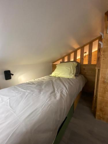 - un lit avec une tête de lit en bois dans l'établissement Genepi loft duplex 4 personnes, à Arâches-la-Frasse