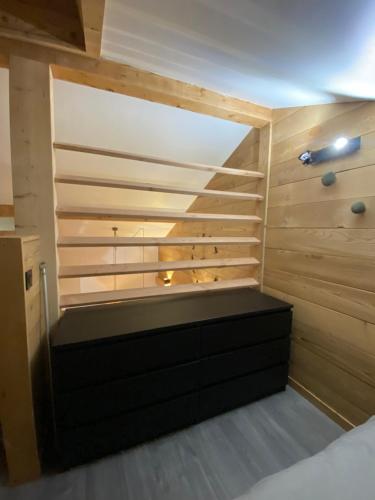 Cette chambre dispose d'un lit avec un mur en bois. dans l'établissement Genepi loft duplex 4 personnes, à Arâches-la-Frasse