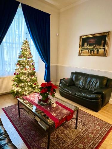 a living room with a christmas tree and a couch at Melbourne House Hotel in London