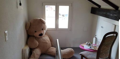 a large teddy bear sitting on a chair in a room at Rooftop double bedroom 