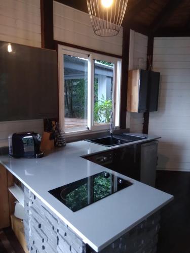a kitchen with a counter with a sink and a window at Le Domaine du Rocher Noir in Pointe-Noire