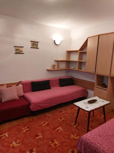 a living room with a red couch and a table at BELE STAZE-Brzece,Kopaonik in Brzeće