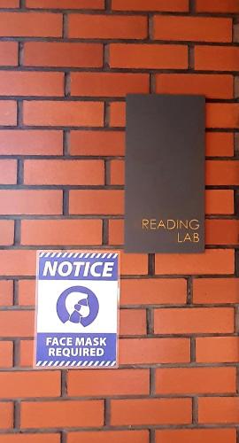 a sign on a brick wall with a notice and a realigning lag at The Glass Homestay Putrajaya in Putrajaya