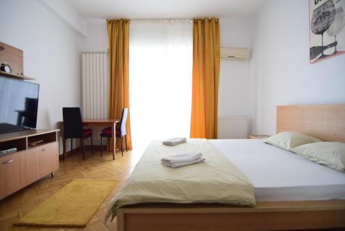 een slaapkamer met een bed, een bureau en een televisie bij Resedinta lui Calin - Calea Victoriei near Royal Palace in Boekarest