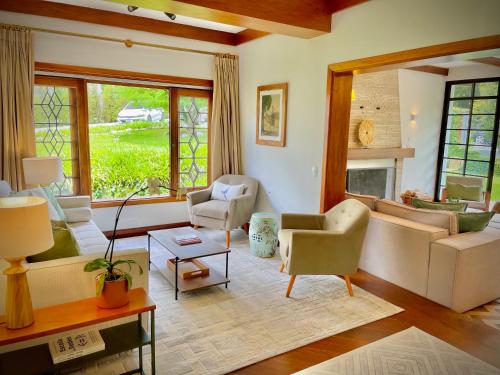 a living room with couches and chairs and a fireplace at Casa Três Rios - Campos do Jordão in Campos do Jordão