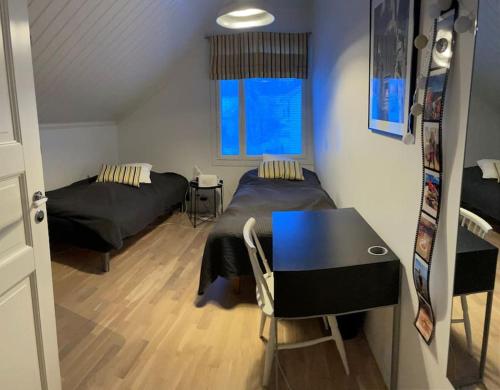 sypialnia z 2 łóżkami, biurkiem i stołem w obiekcie Modern 6-bedroom villa near Tampere city w mieście Tampere