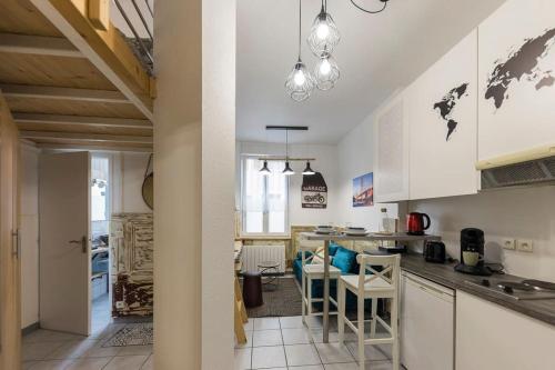 une cuisine avec des armoires blanches et une table et des chaises dans l'établissement St Léon Strasbourg - Studio 3 Pers - Proche centre ville, à Strasbourg