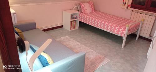 a small bedroom with a bed and a chair at Les Ecureuils in Revin
