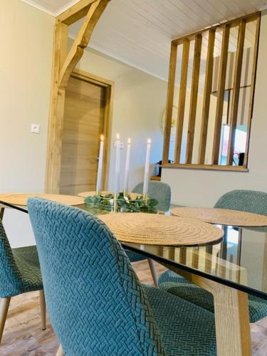 une salle à manger avec une table, des chaises et des bougies dans l'établissement La petite halte, à Lemberg